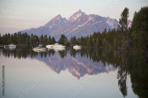 The peaks of the Grand Tetons across Jackson Lake marina in early morning light, Wyoming