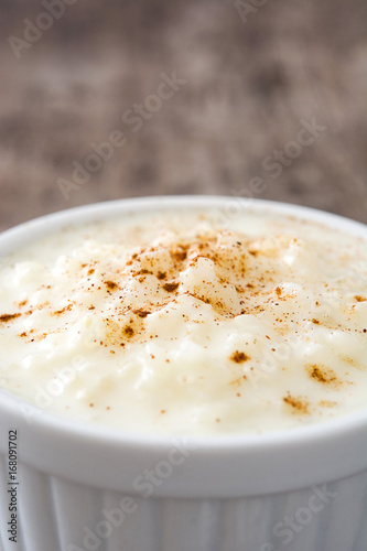 Arroz con leche. Rice pudding with cinnamon on wooden background 