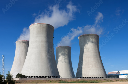 Nuclear power station, cooling towers against blue sky photo