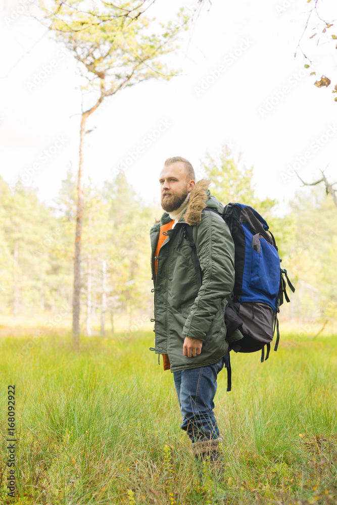 Handsome, bearded guy hiking in swamps and enjoying the views. Camp, adventure, trip and fishing concept. Handsome, bearded guy hiking in swamps and enjoying the views. Camp, adventure, trip and fishing concept.