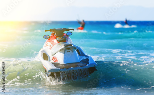 modern jet sways in the surf near shore on background of mountains in Greece