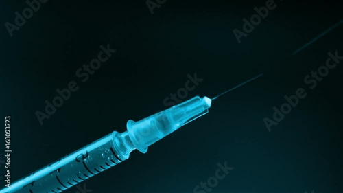 Spraying medicine from the syringe before injection on black background