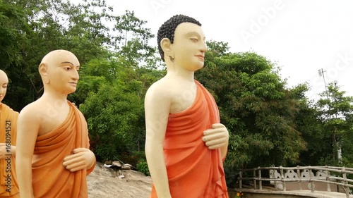 pan from a group walking buddhas behind the Worlds tallest walking  Buddha