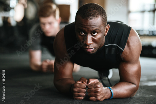 Multiethnic sports strong people make sport exercises in gym.