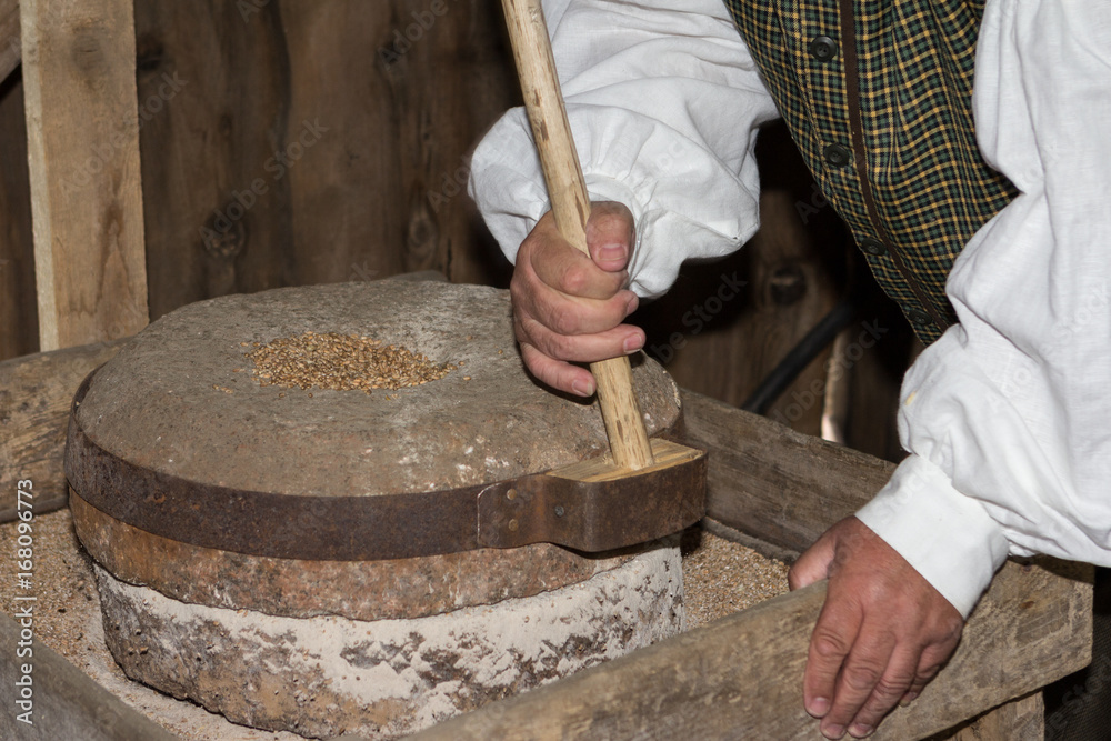 Grain milling with stone pebbles in the ethnographic village of Lithuania