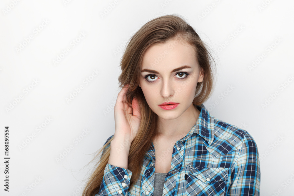 Beauty portrait of young adorable fresh looking blonde woman with hair chaos in blue plaid shirt. Emotion and facial expression concept. Beauty portrait of young adorable fresh looking blonde woman with hair chaos in blue plaid shirt. Emotion and facial expression concept.