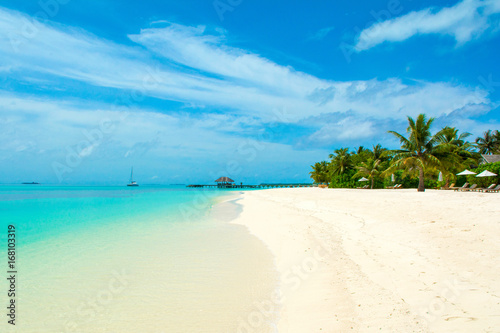 Beautiful sandy beach with sunbeds and umbrellas in Indian ocean  Maldives island