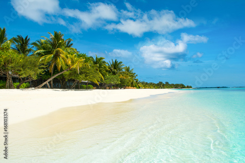 Beautiful sandy beach with sunbeds and umbrellas in Indian ocean, Maldives island