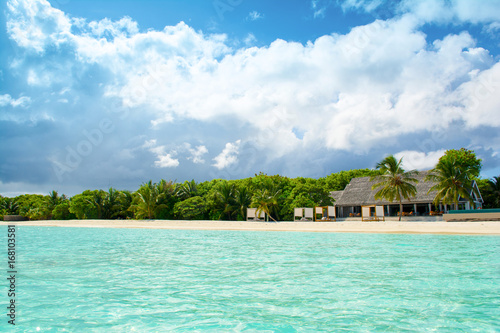 Beautiful sandy beach with sunbeds and pool in Indian ocean, Maldives island © Myroslava