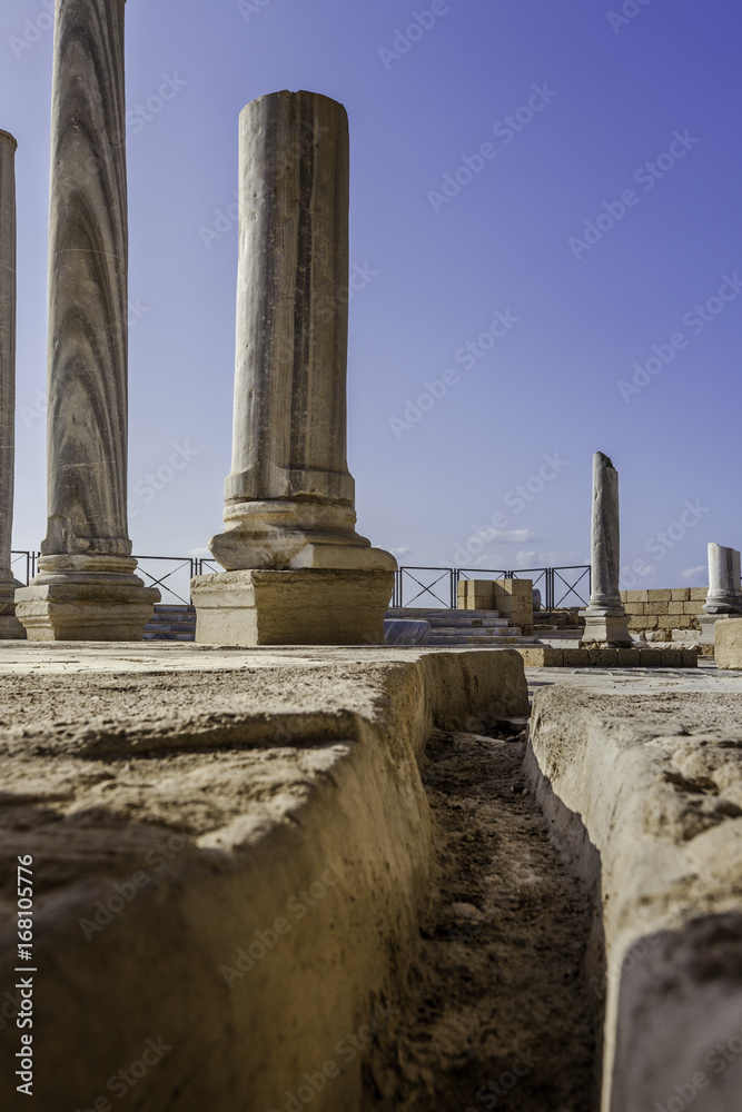 Doric white marble columns remnants from low angle with sewer drain in floor Caesarea national park Doric white marble columns remnants from low angle with sewer drain in floor Caesarea national park