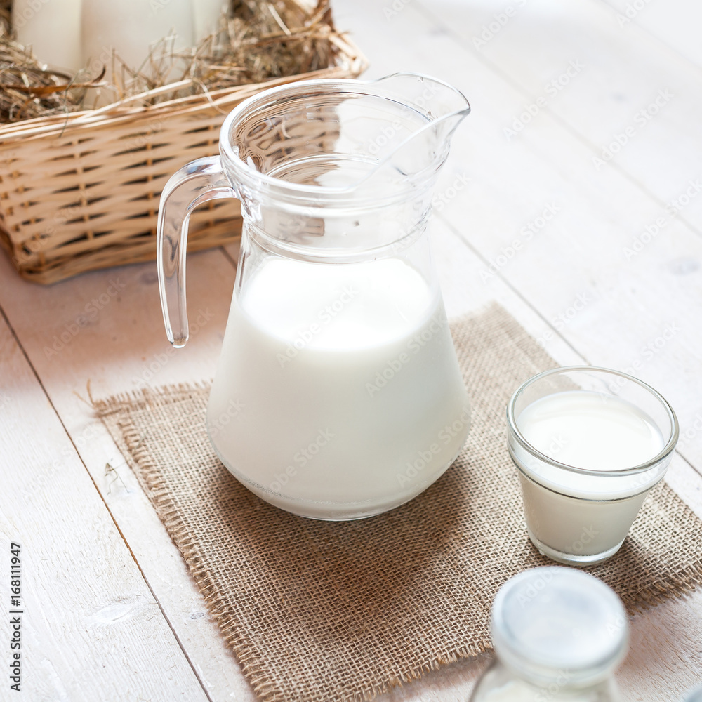 jug of milk and glasses of milk on a wooden rustic table. jug of milk and glasses of milk on a wooden rustic table.