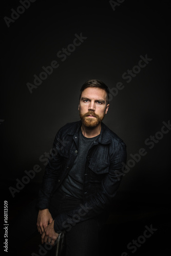 Man looks at camera in dark room © JTobiason