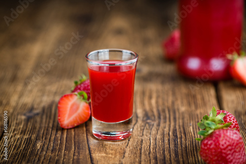 Wooden table with Strawberry liqueur, selective focus