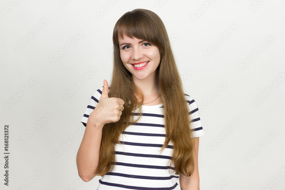 Thumb up. Happy young woman isolated on gray background. Thumb up. Happy young woman isolated on gray background.