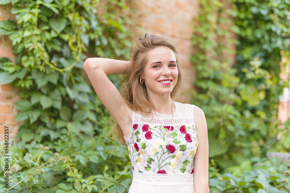 girl on the background of a wall with green foliage girl on the background of a wall with green foliage