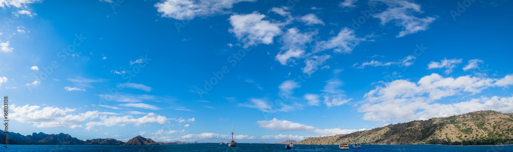 Panoramic blue sky background with white clouds on a sunny day over the sea in flores island, Labuan bajo, Indonesia Panoramic blue sky background with white clouds on a sunny day over the sea in flores island, Labuan bajo, Indonesia