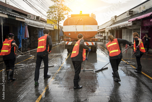 Road sweeper worker cleaning the street market with a broom.