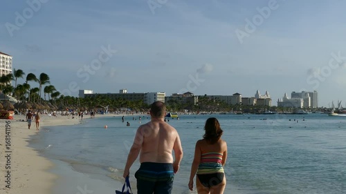 Toerists walking at palm beach on Aruba photo