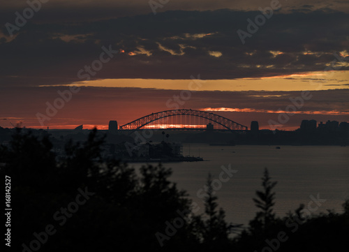 Sunset in the distance over Sydney Harbour Bridge and the city