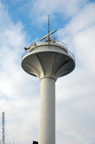 Radar tower against the sky with clouds