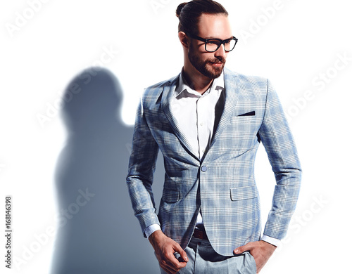 portrait of handsome fashion stylish hipster businessman model dressed in elegant light blue suit in glasses isolated on white