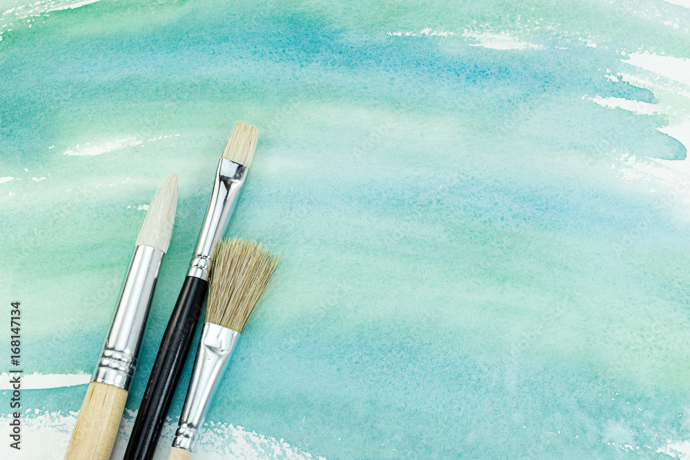 Fototapeta premium hand painted watercolor paper in green colors with paintbrushes