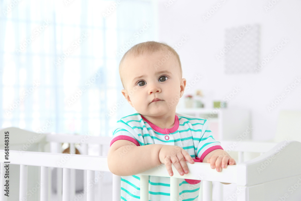 Cute little baby standing in crib at home Cute little baby standing in crib at home