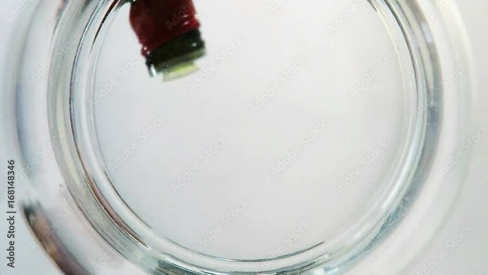 Olivenöl läuft in eine Glasschüssel, Blick von unten durch den Glasboden nach oben