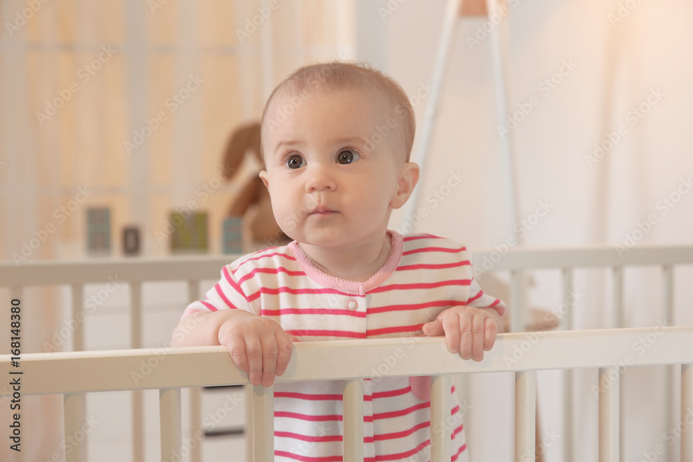 Cute little baby standing in crib at home Cute little baby standing in crib at home