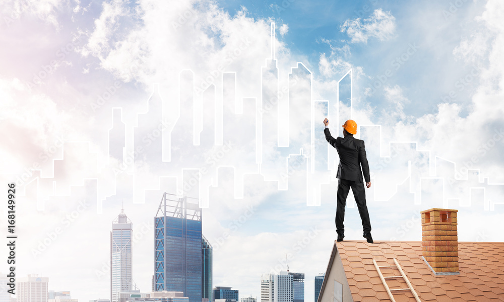 Man architect draw silhouette of modern city on blue sky. Mixed media Man architect draw silhouette of modern city on blue sky. Mixed media