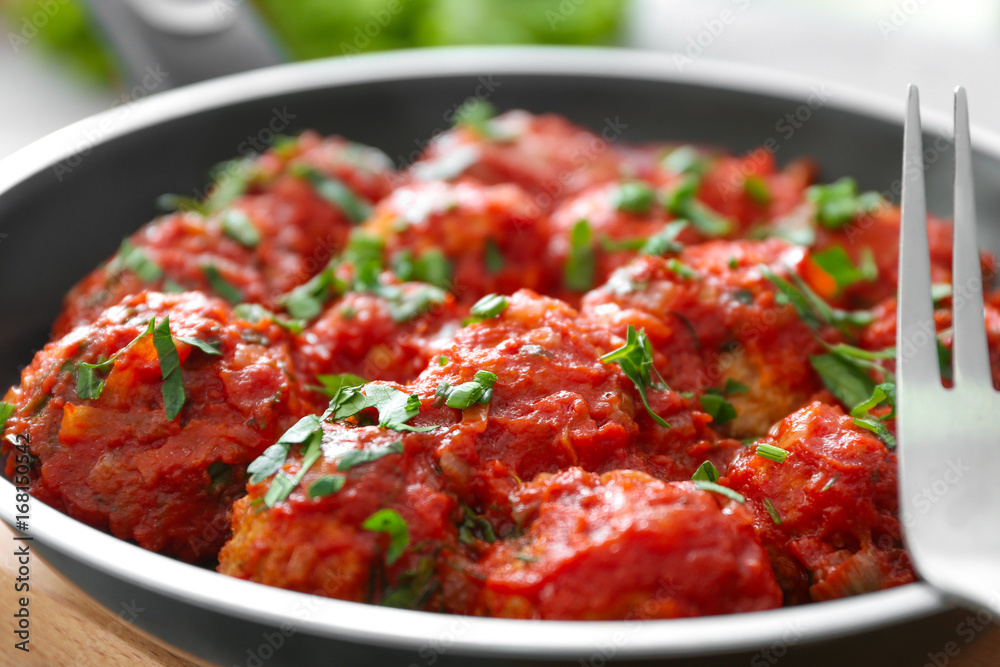 Closeup view of frying pan with turkey meatballs and tomato sauce Closeup view of frying pan with turkey meatballs and tomato sauce