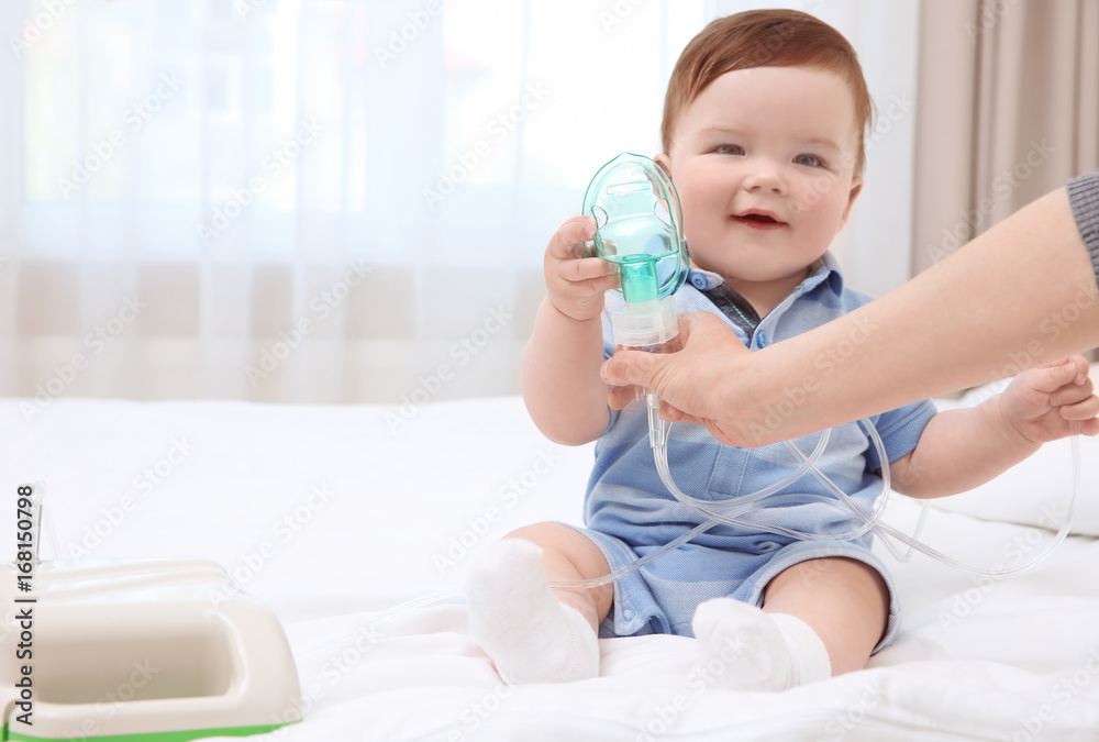 Health care concept. Woman with little baby and nebulizer indoors Health care concept. Woman with little baby and nebulizer indoors