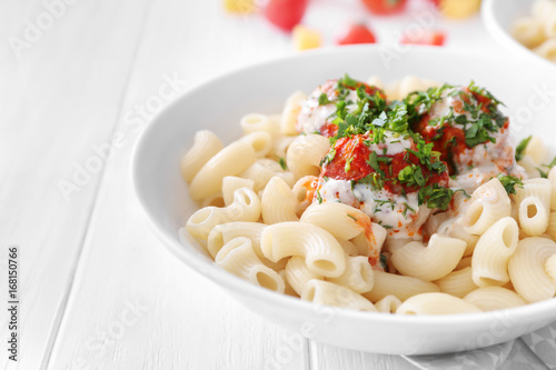 Plate with delicious pasta and turkey meatballs on white wooden table