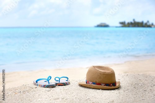 Flip-flops and hat on sea beach. Summer vacation concept