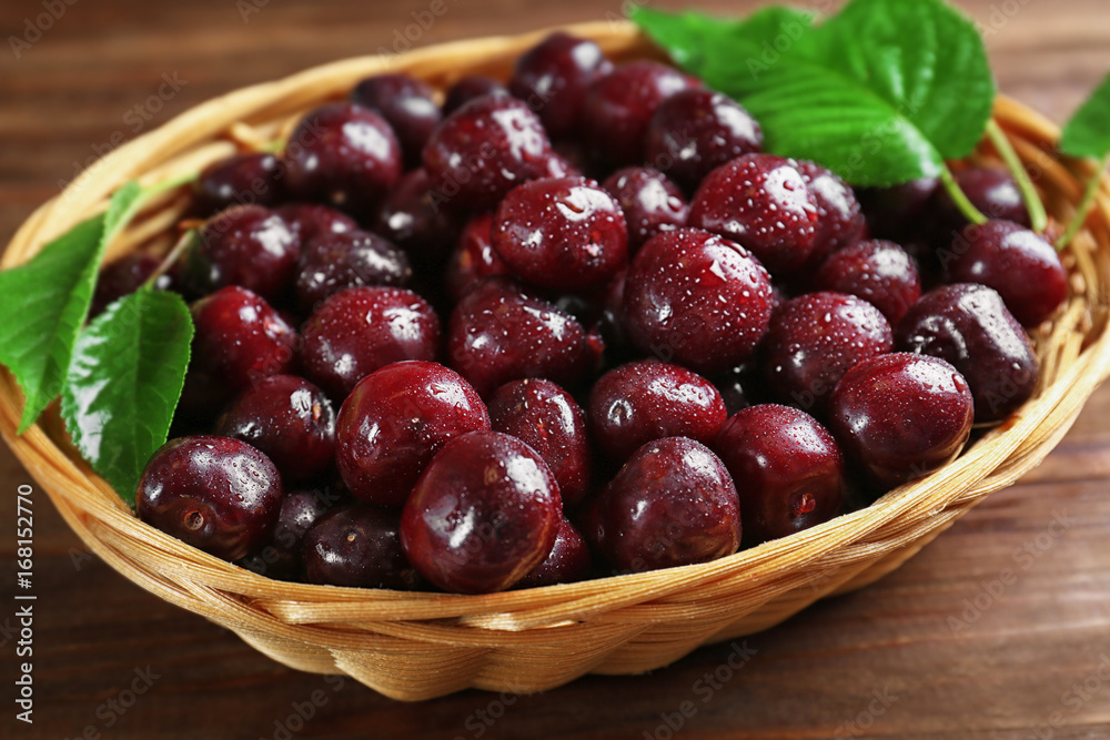 Wicker bowl with fresh ripe cherries on table Wicker bowl with fresh ripe cherries on table