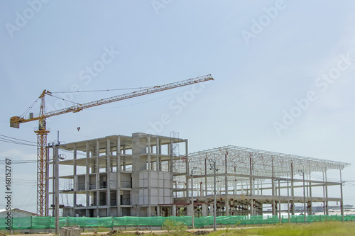 Crane lift with factory under construction.