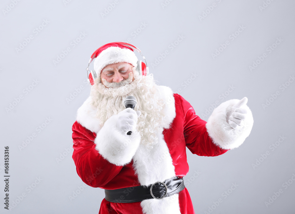 Santa Claus singing Christmas songs on light background Santa Claus singing Christmas songs on light background