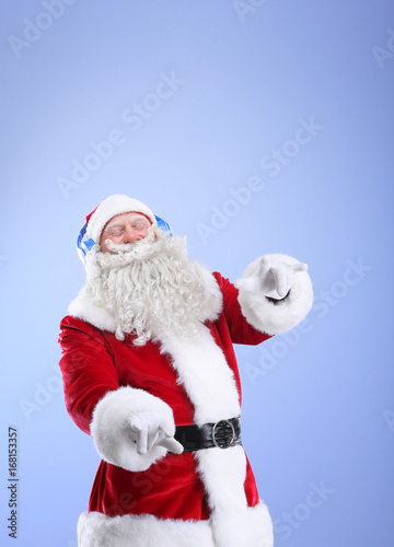 Santa Claus listening to music on color background © Africa Studio