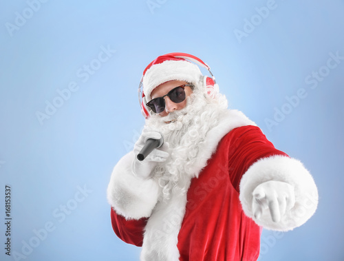 Santa Claus singing Christmas songs on color background © Africa Studio