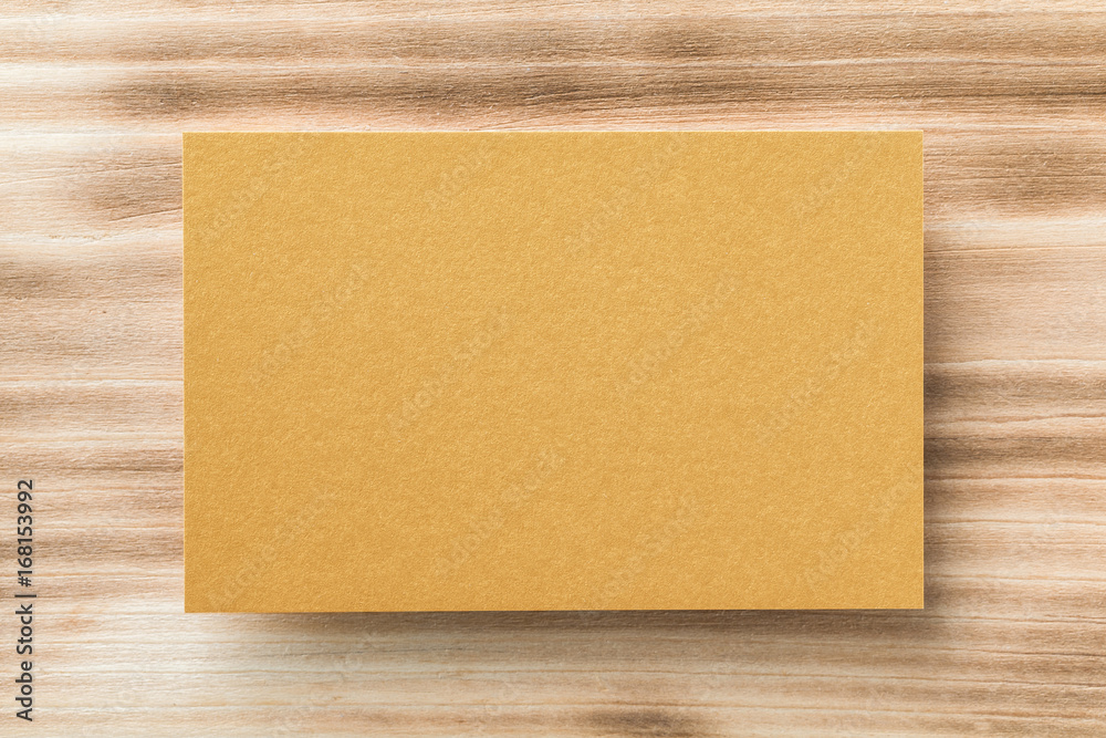 Closeup mockup of blank golden horizontal business card at natural wooden background. Closeup mockup of blank golden horizontal business card at natural wooden background.
