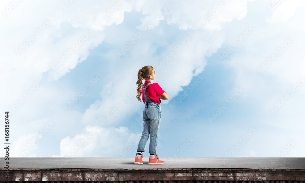 Concept of careless happy childhood with girl looking far away Concept of careless happy childhood with girl looking far away