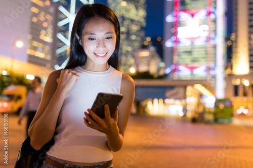 Woman holding with cellphone at night photo