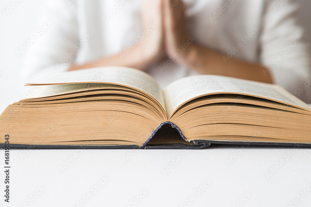 Opened bible in the quiet, light atmosphere. Prayer time on sunday. Woman's hands on the bible. Opened bible in the quiet, light atmosphere. Prayer time on sunday. Woman's hands on the bible.