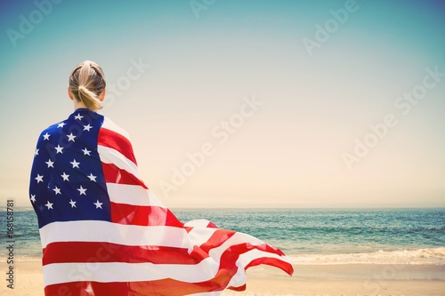 Woman holding a USA flag in the beach photo