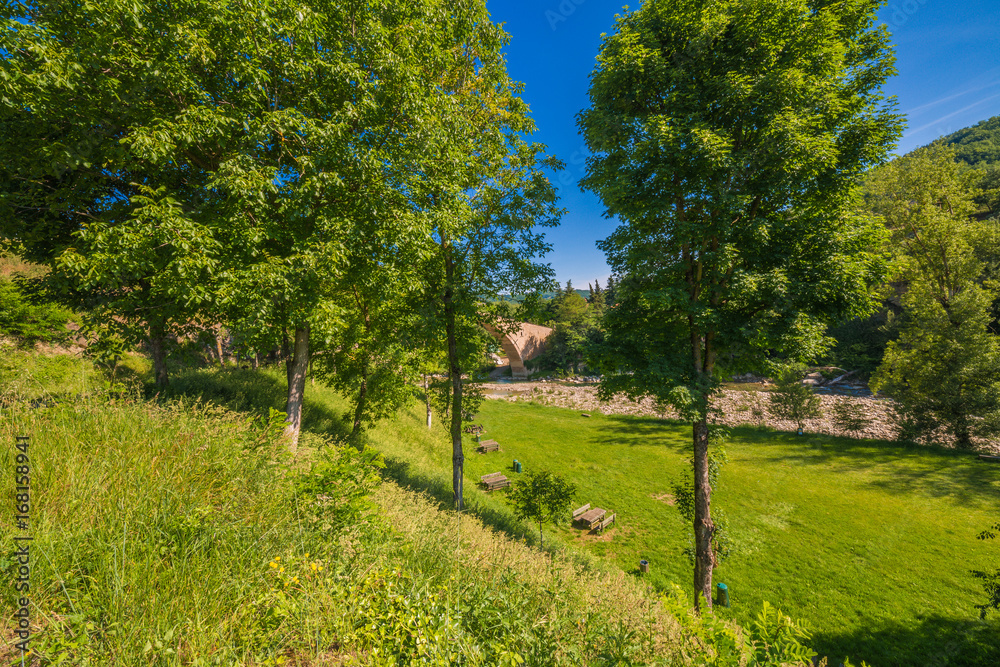 green countryside around ancient bridge