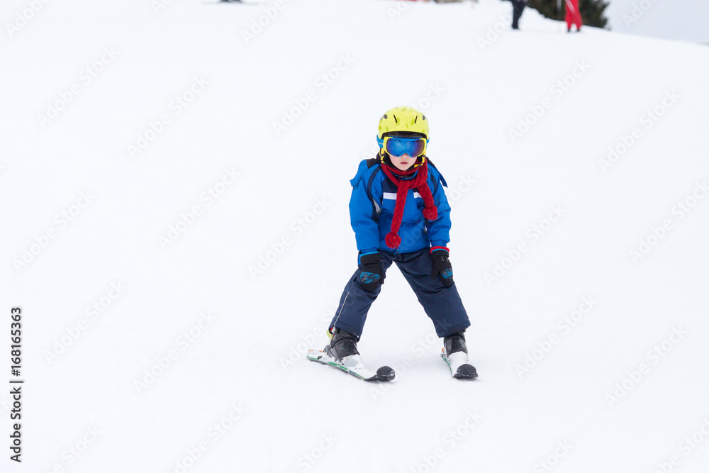 Young child, skiing on snow slope in ski resort in Austria