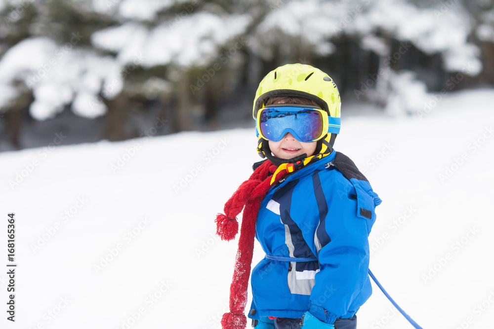 Cute little boy, learning to ski in Austrian ski resort