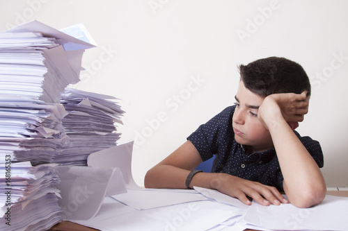 Fotografie student on the desk with stacked papers