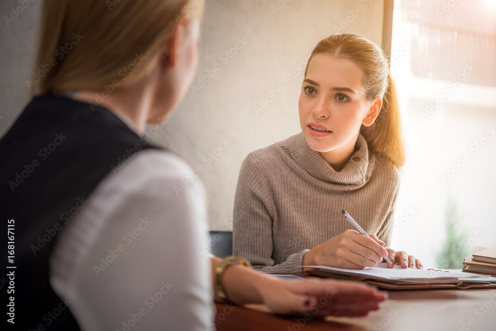 Two pretty women studying together at a library 