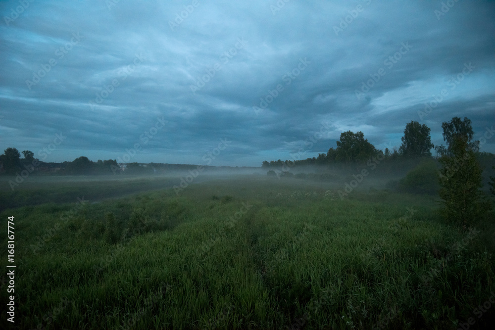 Landscape with a fog. Summer evening in the countryside.